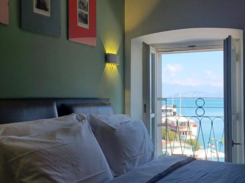 a bedroom with a bed and a view of the ocean at Relais al Porto Suite ORA in Peschiera del Garda