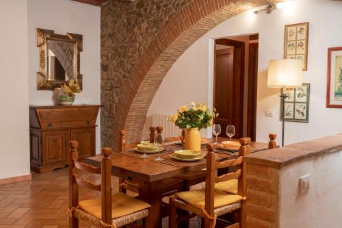 a dining room with a wooden table and chairs at Casa Nataly Chianti - Jeky Stay in Castelnuovo Berardenga