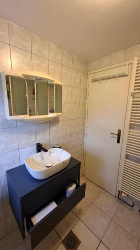 a bathroom with a white sink and a door at Aventurin Rooms in Slunj