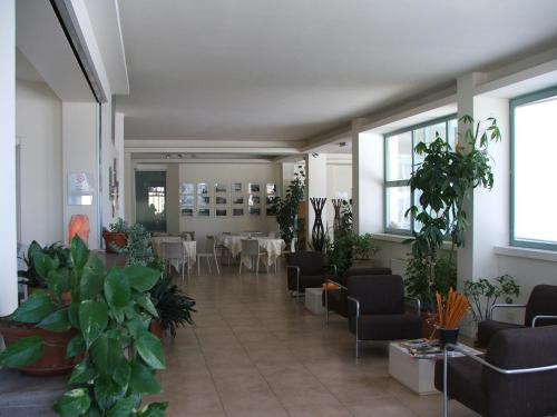 a lobby with tables and chairs and plants at Lieta Sosta in Colfiorito