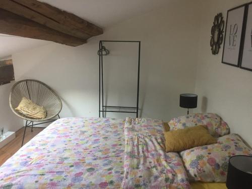 une chambre avec un grand lit et une chaise dans l'établissement LES GITES CHEROIS maison Esprit cabane 5 personnes, à Les Chères