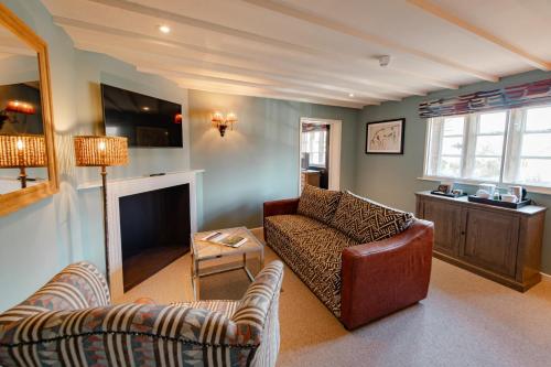a living room with a couch and a television at The Manor House Hotel in Moreton in Marsh