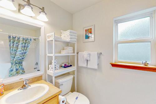ein Badezimmer mit Waschbecken und Toilette und einem Fenster in der Unterkunft Blue Wave Cottage in Pacific Beach