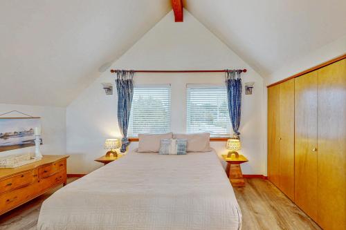 Schlafzimmer mit einem großen Bett und blauen Vorhängen in der Unterkunft Blue Wave Cottage in Pacific Beach
