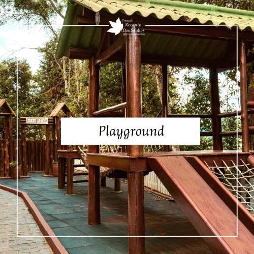 a slide at a playground with a sign that reads playground at Pousada Recanto dos Sonhos in Campos do Jordão