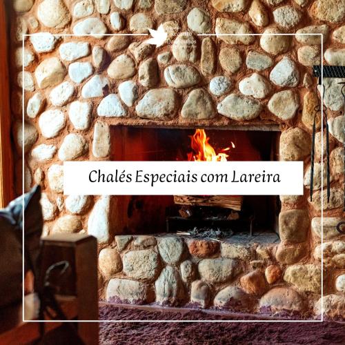a brick fireplace with a fire in it at Pousada Recanto dos Sonhos in Campos do Jordão