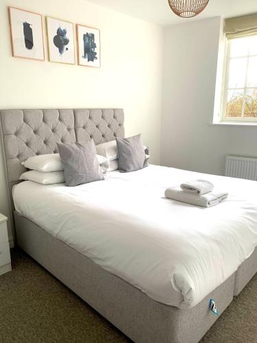 a bedroom with a large bed with white sheets and pillows at West Street Mews - Serviced Accommodation in Exeter