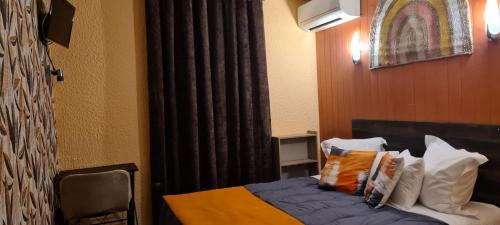 a hotel room with a bed with pillows at Hôtel L'Etoile Aéroport - A61 in Carcassonne