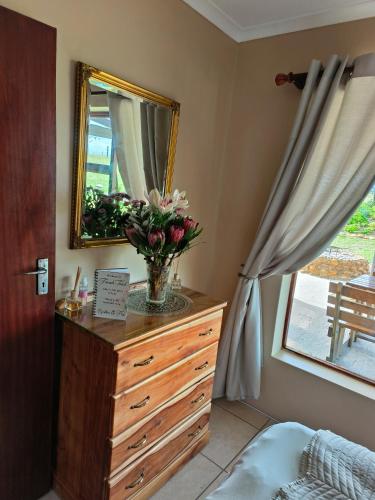 a bedroom with a dresser with a mirror and flowers on it at French Toast in George