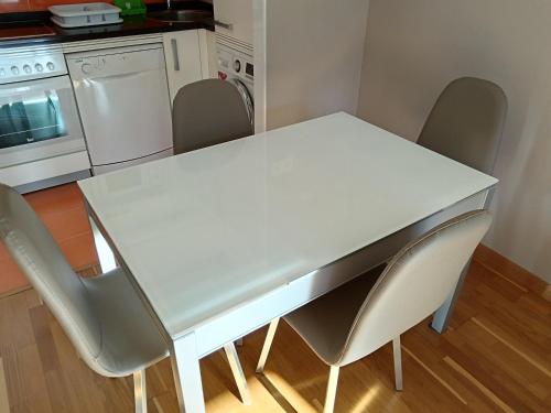 a white table and chairs in a kitchen at Apartamento en Puerto de Vega in Navia