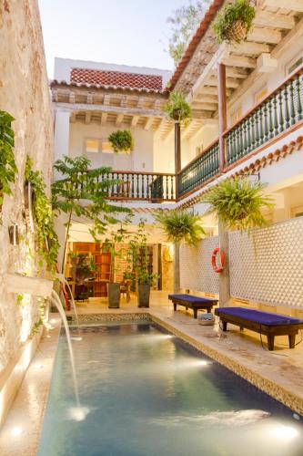 a swimming pool with a fountain in a house at Casa Pizarro Hotel Boutique in Cartagena de Indias