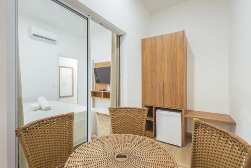 a room with a table and chairs and a desk at Kaliman Pousada in Ubatuba