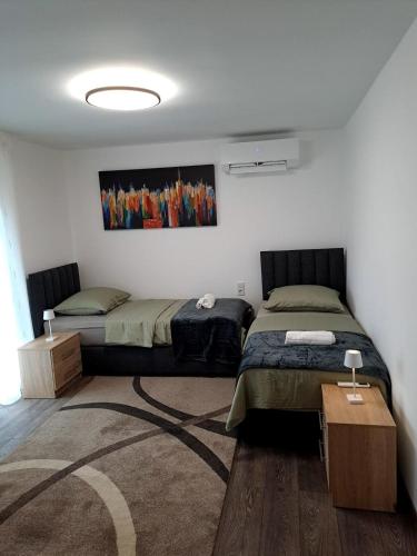 a bedroom with two beds and a rug at Dedin dvorac in Valpovo