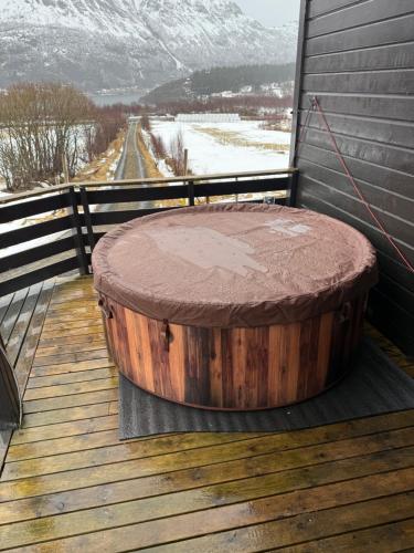 a large wooden barrel sitting on a deck at Hus i Olderfjord in Lyngværet