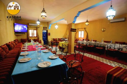 a long table in a room with tables and chairs at Kasbah Du Berger & Piscine in Merzouga