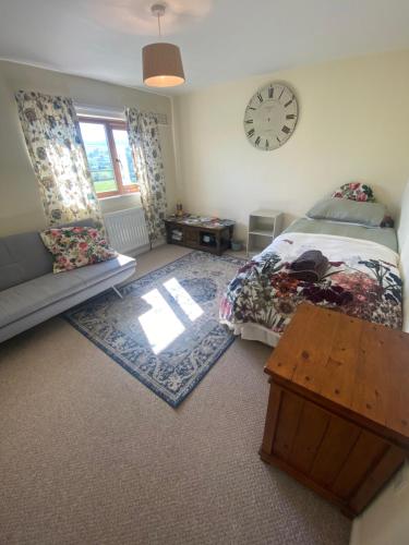 a bedroom with a bed and a clock on the wall at 4 beds, private parking, gr fl bedroom & shower WC in Wensley