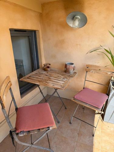 - deux chaises et une table dans une chambre avec un miroir dans l'établissement Le Sainte-Victoire - Studio cosy avec sa jolie terrasse - Centre ville historique, à Aix-en-Provence