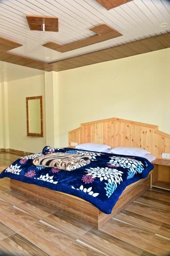 a large bed with a blue comforter in a bedroom at Devcasa By Nomadic Den Manali in Manāli