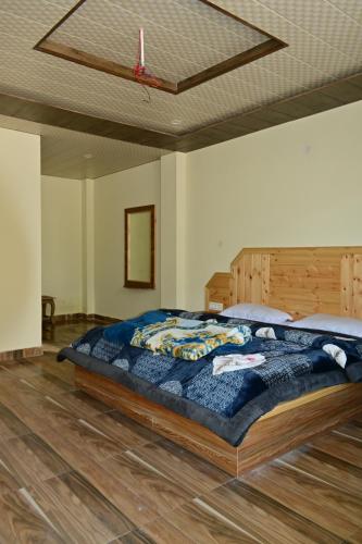 un grande letto in una camera da letto con pavimento in legno di Nomadic Den Manali a Manāli
