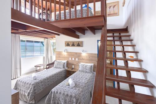a room with two beds and a staircase at Kaliman Pousada in Ubatuba