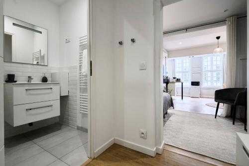 Il comprend une cuisine blanche et un salon avec un lit. dans l'établissement Appartement Lumineux & Equipé - 3 - Mon Groom, à Troyes