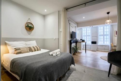 une chambre avec un grand lit et un salon dans l'établissement Appartement Lumineux & Equipé - 3 - Mon Groom, à Troyes