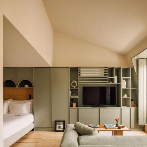 a bedroom with a bed and a couch and a tv at The Verse in Lisbon