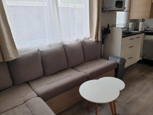 un salon avec un canapé et une table dans l'établissement Mobil-home 6 personnes Agde - Grau d'Agde, au Grau-dʼAgde