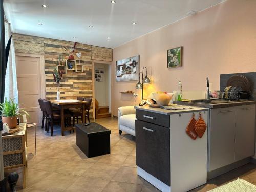 une cuisine et un salon avec une table et un comptoir dans l'établissement Maison de bourg près du château, à Polignac