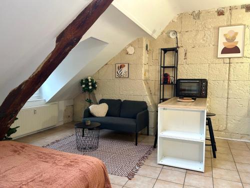 - une chambre mansardée avec un canapé et une télévision dans l'établissement Terracotta - Quai de la Loire - Cozy, à Tours