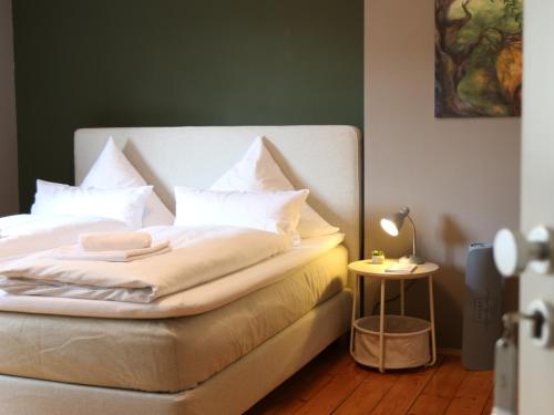a bedroom with a bed with white sheets and pillows at Landgasthof Kirschgarten I Stay & Sleep by Apart You in Ingelheim am Rhein