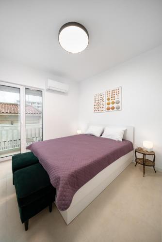 a white bedroom with a bed and a large window at WineAfterSun Chaniotis Beach&Waves steps to beach in Hanioti