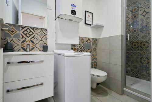 une salle de bain blanche avec toilettes et douche dans l'établissement Appartement Cosy & Equipé - 5 - Mon Groom, à Troyes