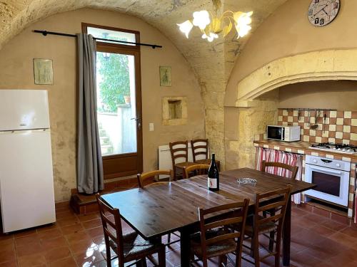 une cuisine avec une table en bois et un réfrigérateur dans l'établissement Gîte dans un domaine viticole, entre Montpellier et Sète, proche de la mer, à Saussan