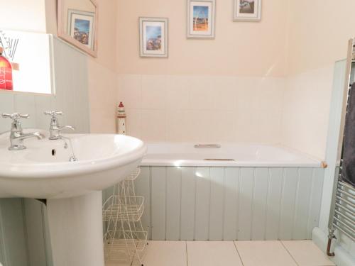 a bathroom with a sink and a bath tub at Chapel Cottage in Ebberston
