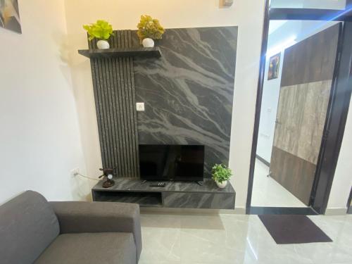 a living room with a tv and a couch at 2BHK Stay in Dwarka in New Delhi