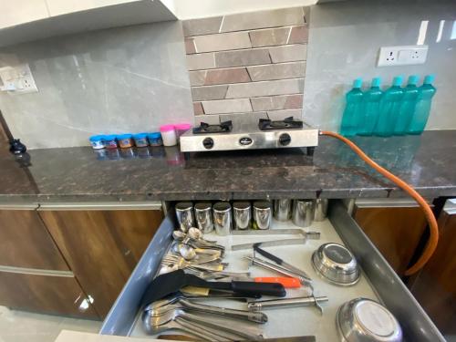 a kitchen counter with a stove and some utensils at 2BHK Stay in Dwarka in New Delhi