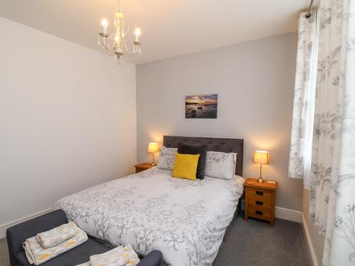 ein Schlafzimmer mit einem Bett und einem Kronleuchter in der Unterkunft The Bungalow in Whitby
