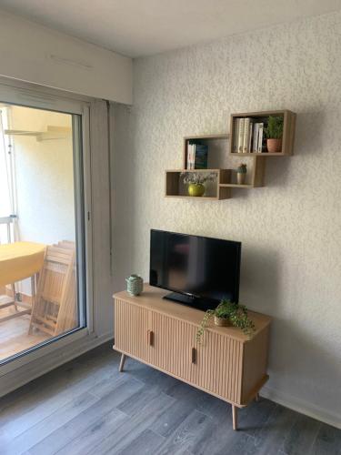 un salon avec une télévision à écran plat sur un mur dans l'établissement Studio calme 4 personnes 400 m de la plage sur la presqu'île de St mandrier proche toulon, à Saint-Mandrier-sur-Mer