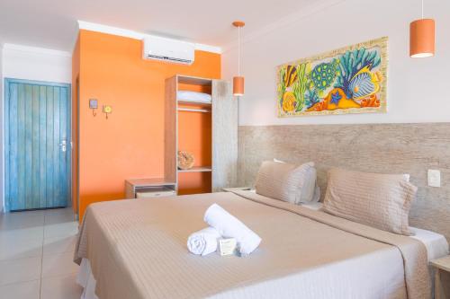 a bedroom with a large bed with towels on it at Kaliman Pousada in Ubatuba