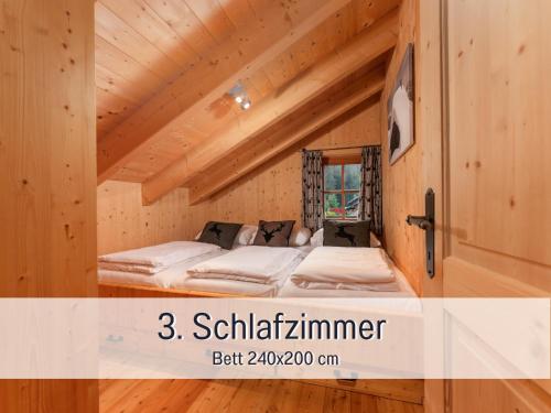 a bed in a room in a wooden house at Chalet am Oberhausberg, Region Schladming Dachstein in Haus im Ennstal