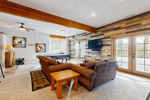 a living room with two couches and a pool table at Cascade Lakeview Log Cabin in Cascade