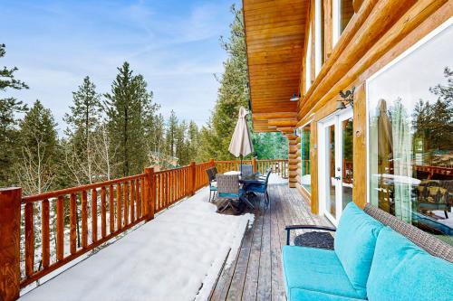 a deck with a couch and chairs on a house at Cascade Lakeview Log Cabin in Cascade