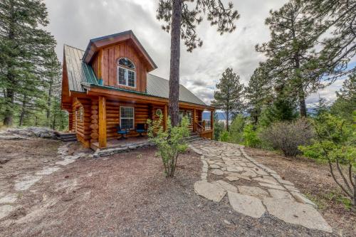 a cabin in the woods with a stone walkway in front at Cascade Lakeview Log Cabin in Cascade