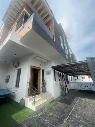 un edificio bianco con tenda da sole e patio di Aqua lodge a Lekki