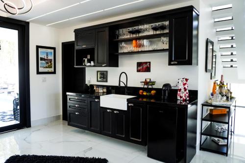 una cucina con armadi neri e lavandino di Fletcher American Manor Hotel & Resort a Prado