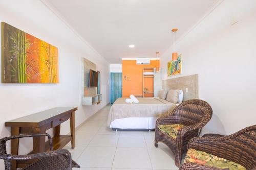 a bedroom with a bed and a table and chairs at Kaliman Pousada in Ubatuba