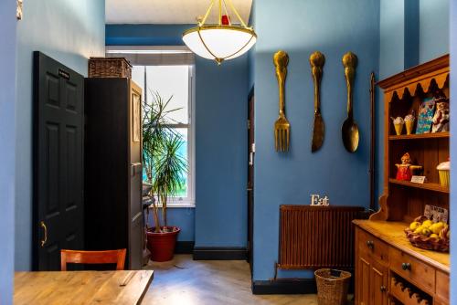 a dining room with blue walls and a table at Mulberry House in Llandudno