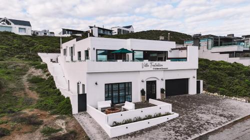 a white house on top of a hill with houses at Yzerfontein Villa Fantastica - No Loadshedding in Yzerfontein