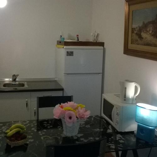 a kitchen with a counter and a refrigerator and a table at Alegria Rooms in Porto